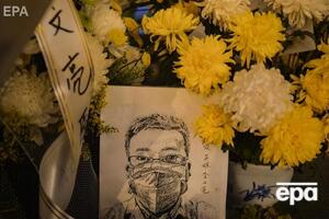 У Китаї несуть квіти до клініки лікаря, який одним із перших повідомив про новий коронавірус і дістав покарання від поліції. Фоторепортаж