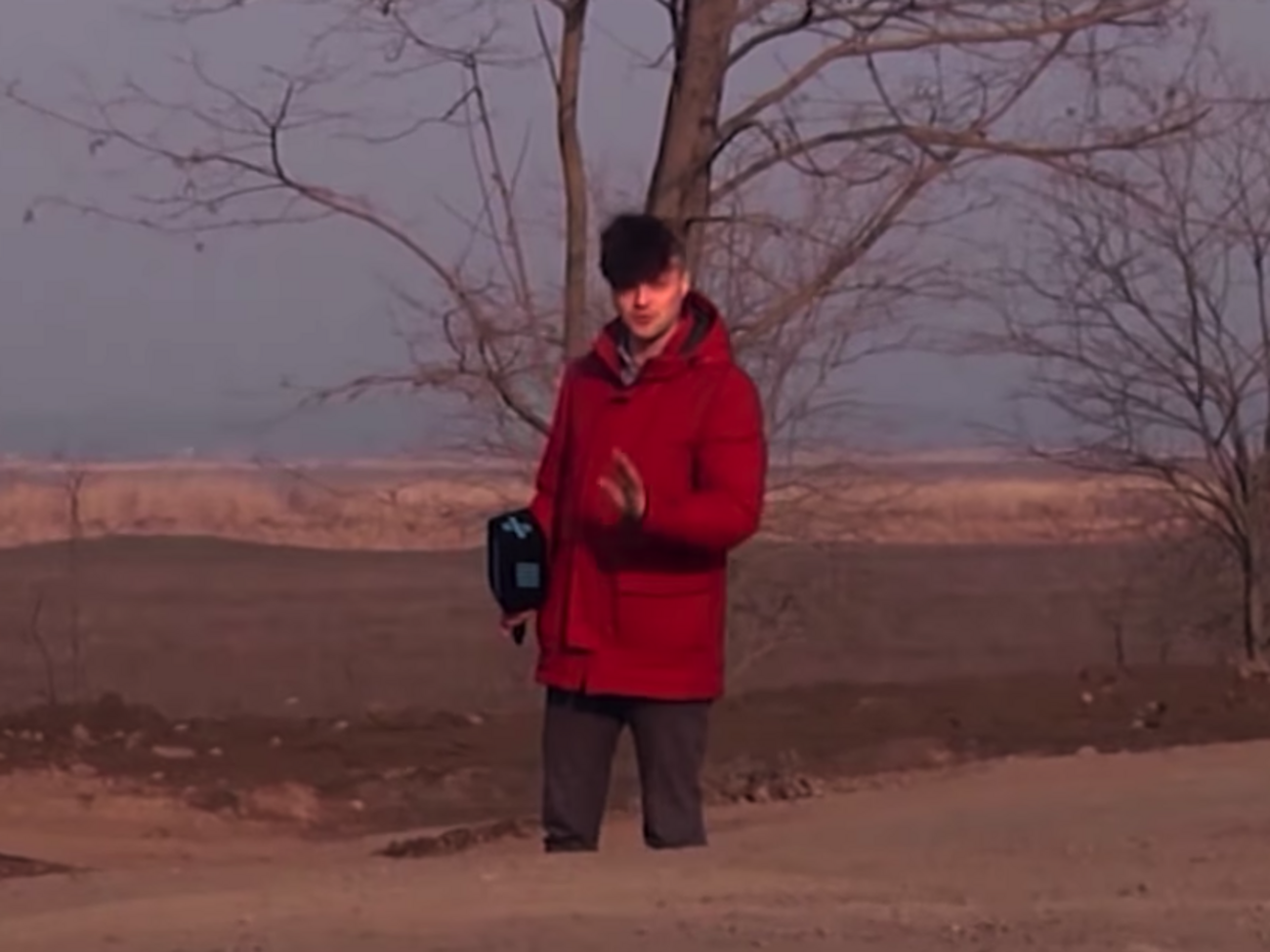 Авторы показали участок дороги, где журналист&nbsp;стоит&nbsp;в яме по колено