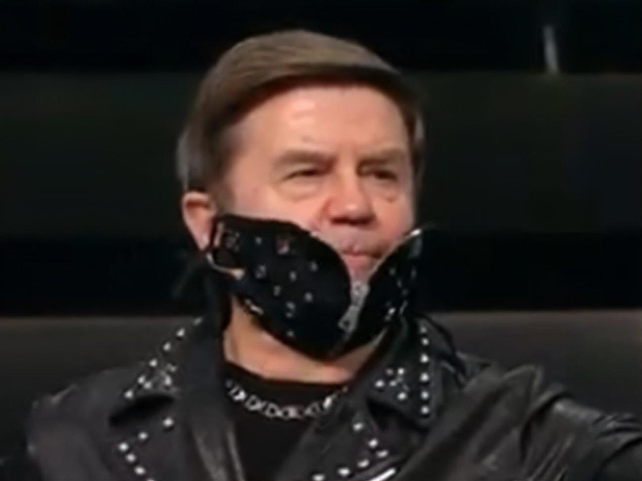 Черная маска с заклепками дополняла образ ведущего, одетого в черную куртку-косуху