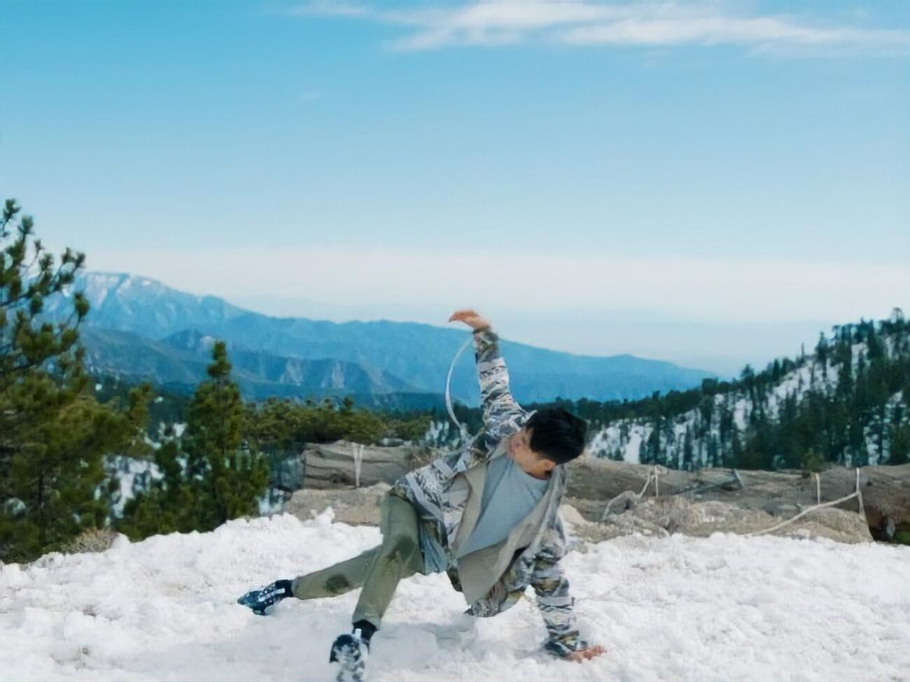 Герой ролика виконує танець серед гір