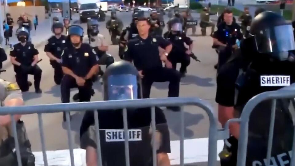 Поліцейські стоять на коліні перед протестувальниками в місті Де-Мойн (штат Айова)