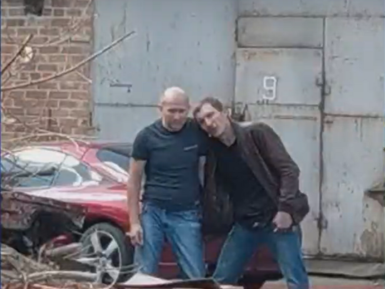 Зловмисник (праворуч) та голова карного розшуку (ліворуч) їдуть в авто, яке супроводжує поліція