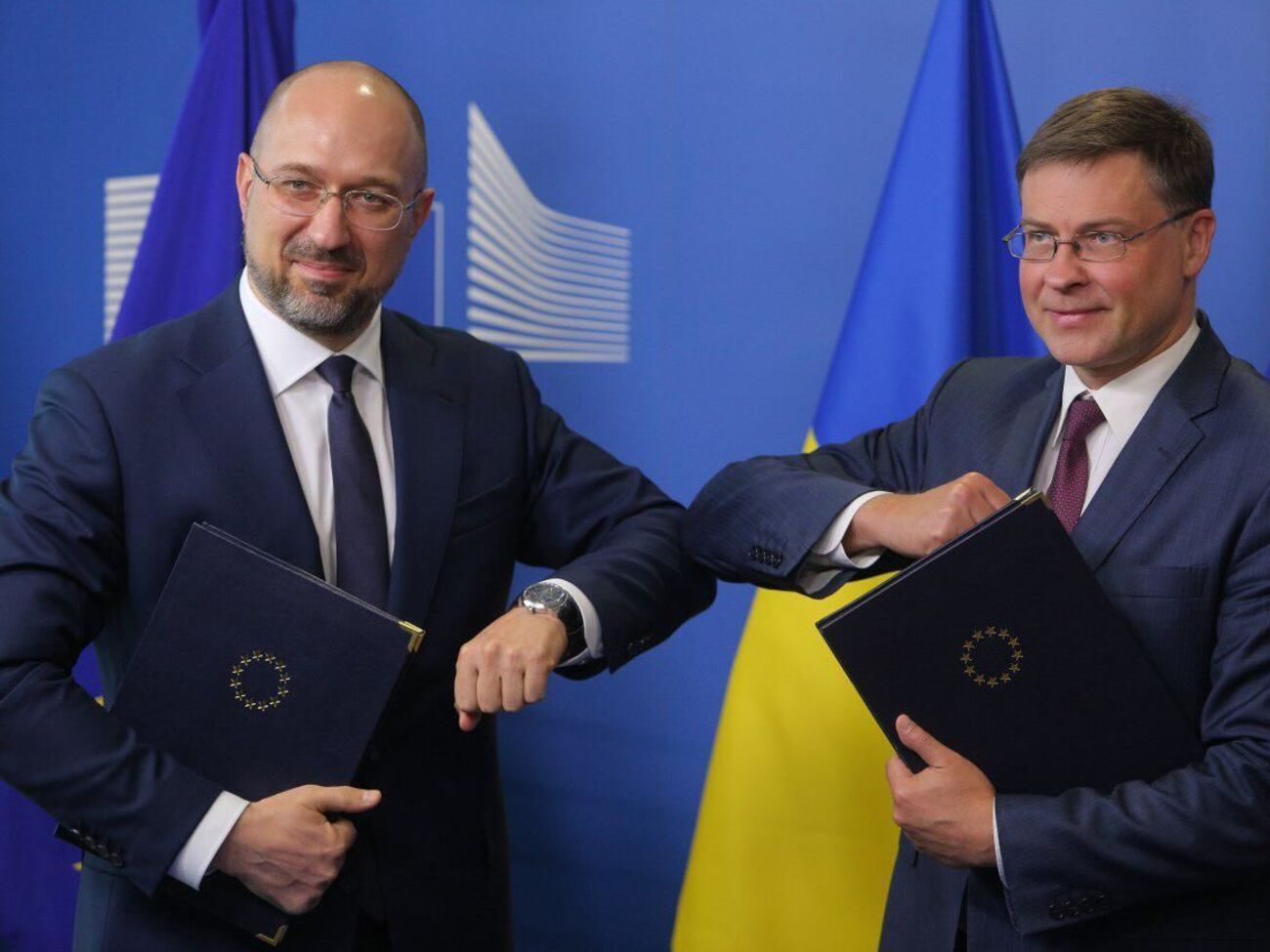 Український прем'єр Денис Шмигаль і єврокомісар Валдіс Домбровскіс після підписання меморандуму про надання макрофінансової допомоги