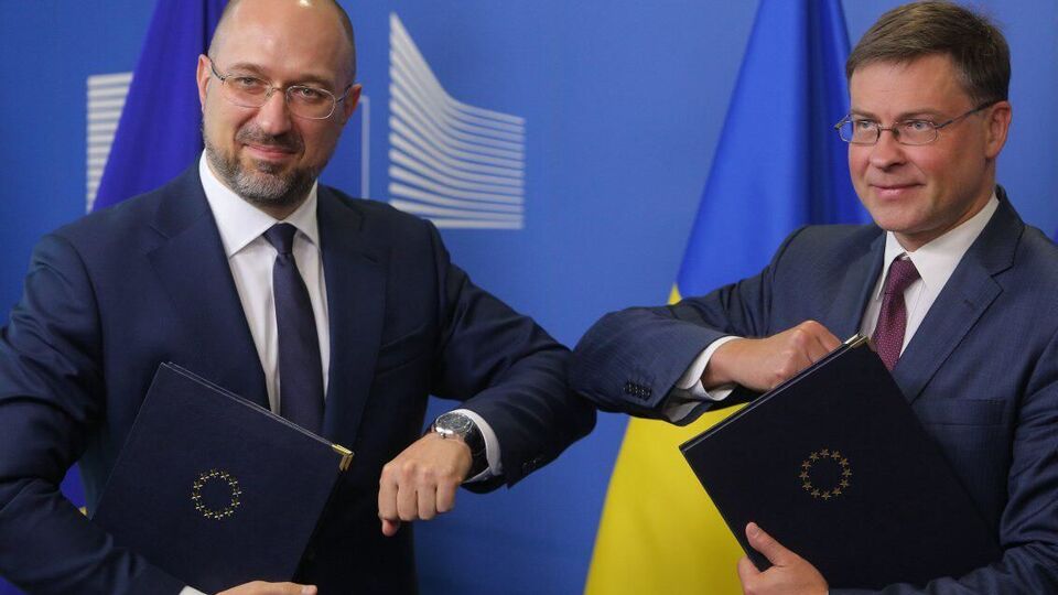 Український прем'єр Денис Шмигаль і єврокомісар Валдіс Домбровскіс після підписання меморандуму про надання макрофінансової допомоги