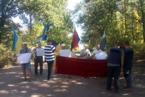 Митингующие держат плакаты с лозунгами "Мир на Донбассе – это не предательство национальных интересов", "Донбасс против чужих хозяев"