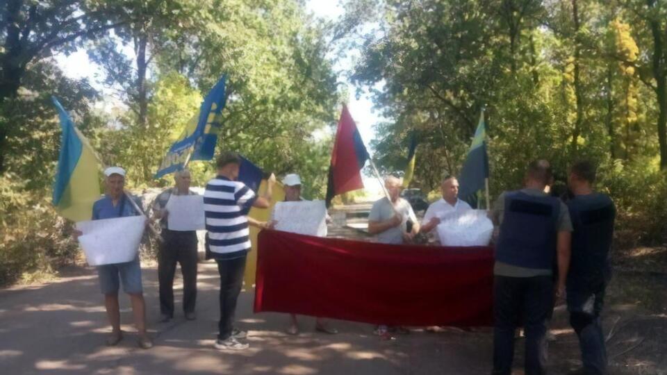 Митингующие держат плакаты с лозунгами "Мир на Донбассе – это не предательство национальных интересов", "Донбасс против чужих хозяев"