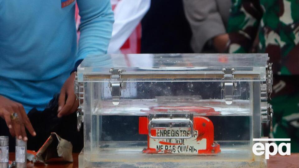 В Индонезии показали заполненный водой прозрачный контейнер, внутри которого находится оранжевый корпус черного ящика