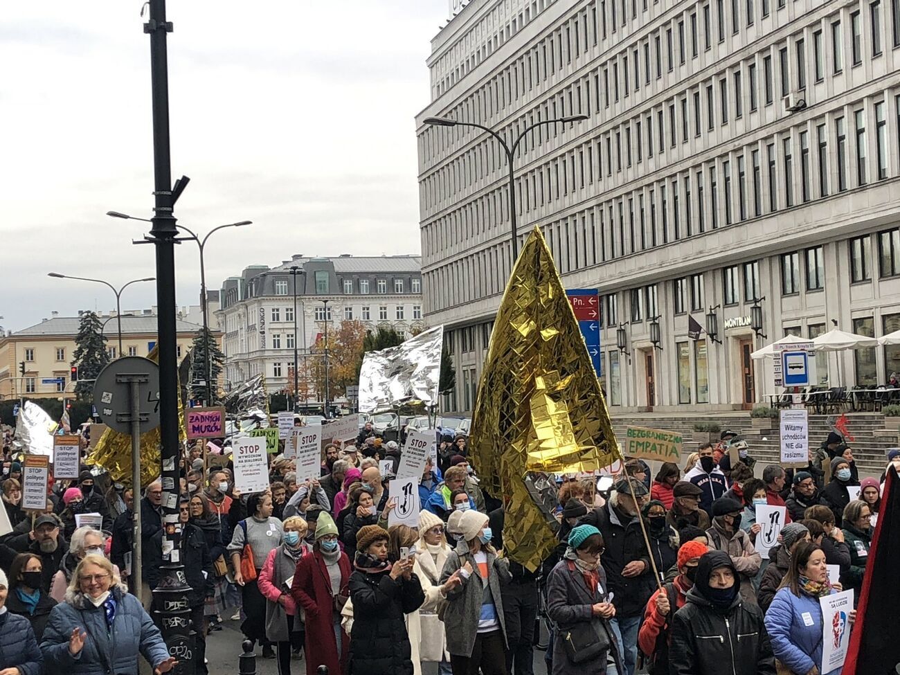 Активисты несли плакаты и тепловые одеяла как напоминание о недавних смертях мигрантов на границе
