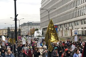 Активисты несли плакаты и тепловые одеяла как напоминание о недавних смертях мигрантов на границе