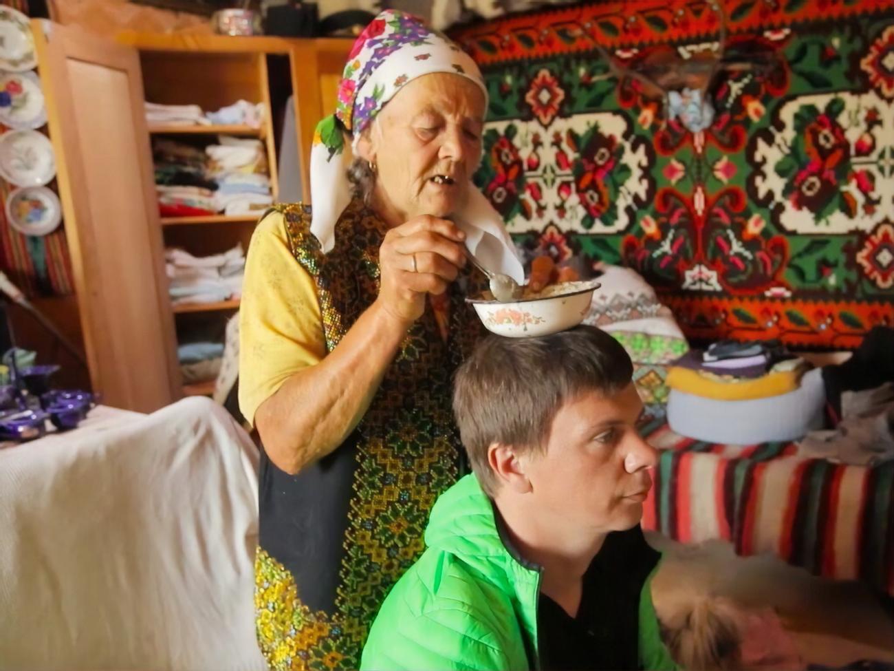 Український телеведучий Дмитро Комаров слухає пророцтва карпатської мольфарки Марії Цвілинів