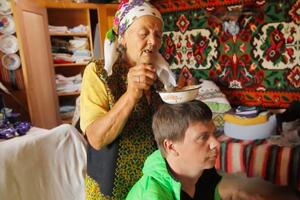 Український телеведучий Дмитро Комаров слухає пророцтва карпатської мольфарки Марії Цвілинів