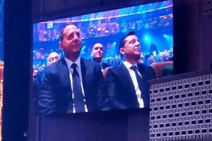 Зеленский (справа на экране) пришел на концерт с Ермаком (слева)