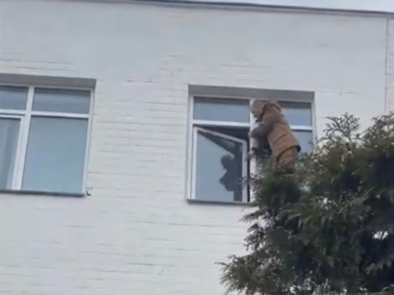 Мужчина находится возле окна на четвертом этаже