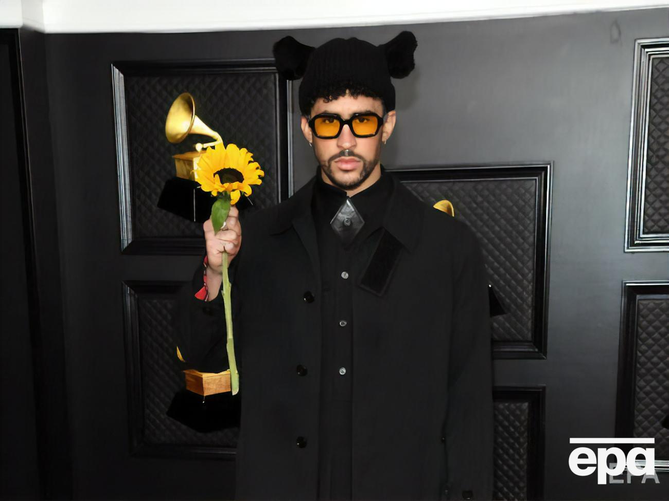 Bad Bunny відвідав "Греммі 2021" у чорному пальто, плісированій сукні і високих черевиках на шнурівці, доповнивши образ шапкою з вухами