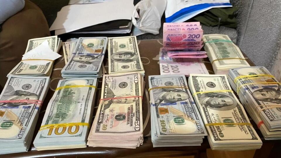 Під час обшуків у Києві та Одеській області правоохоронці вилучили готівку та банківські картки