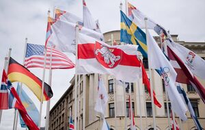 Лукашенко назвал "вандализмом" замену государственного флага Беларуси в риге на бело-красной-белый (в центре)