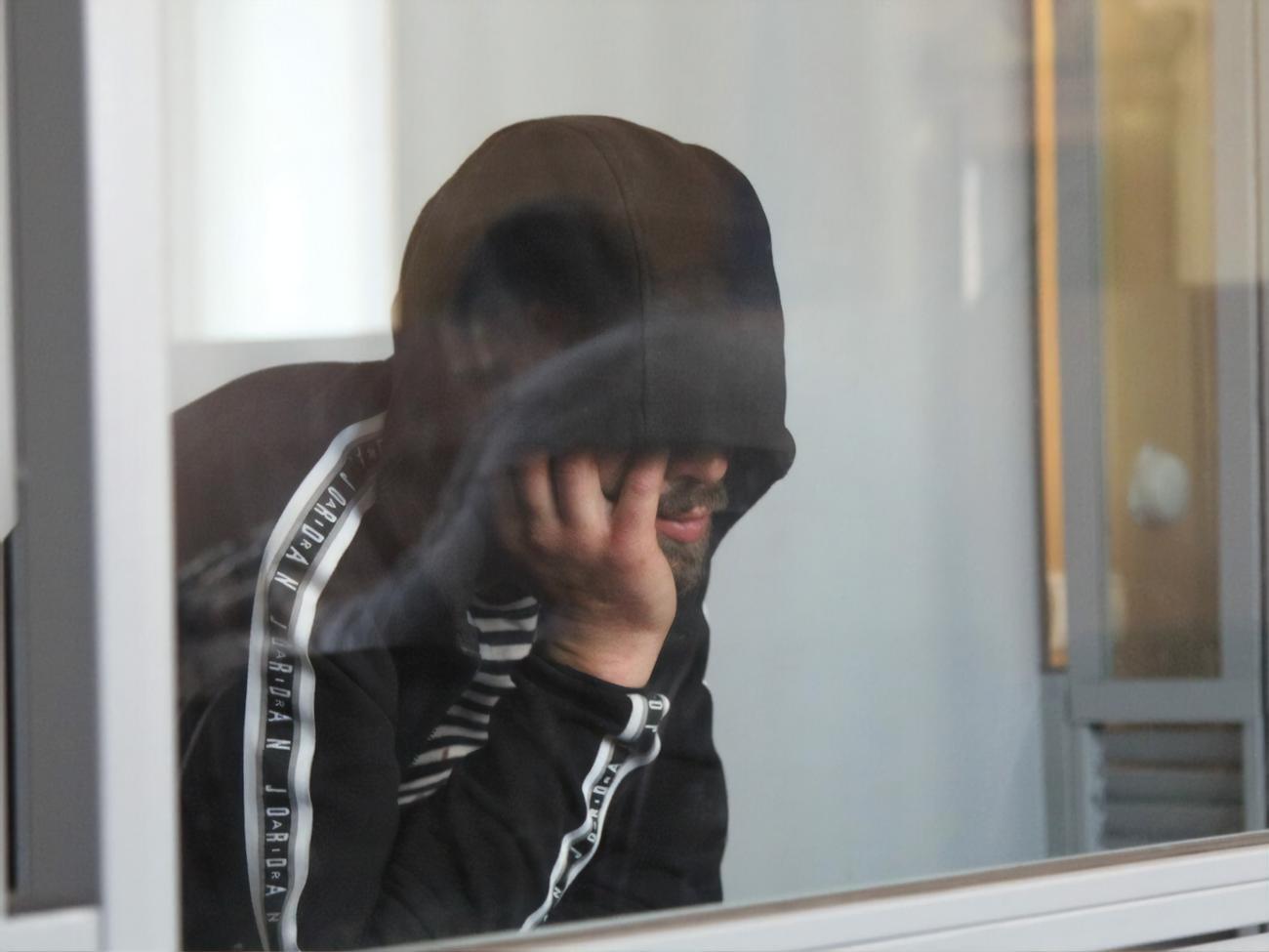 На засіданні суду підозрюваний говорив тихо й ховав обличчя під капюшоном