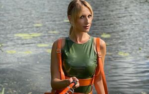 Никитюк предстала в боди цвета хаки, высоких сапогах и с удочкой в руках