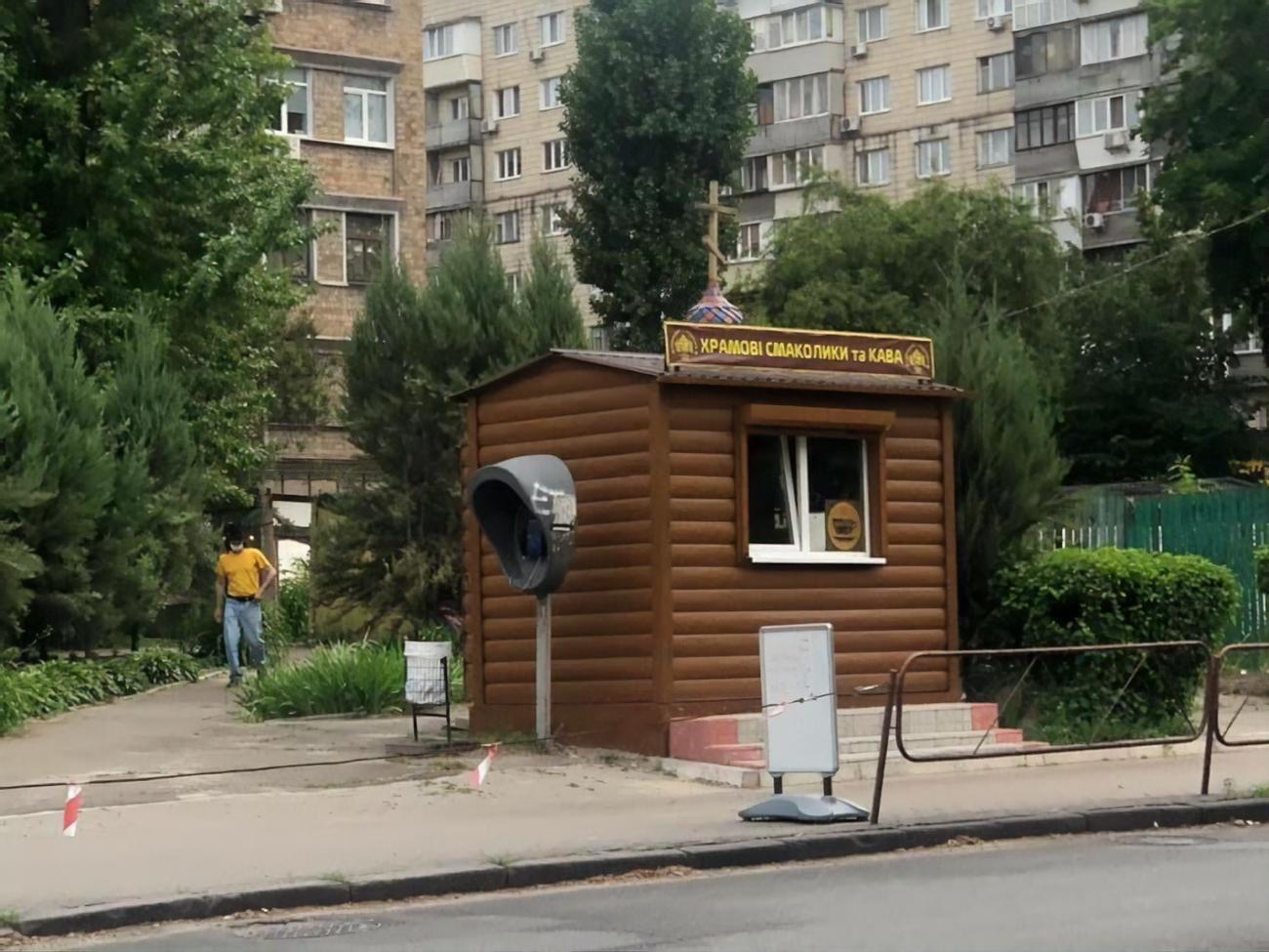 На вывеске ларька написано: "Храмовые лакомства и кофе"