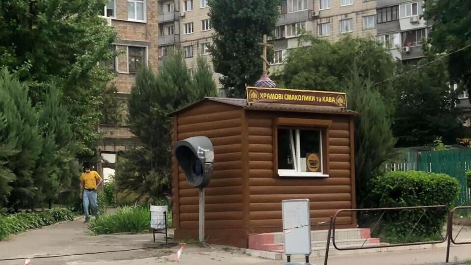 На вывеске ларька написано: "Храмовые лакомства и кофе"