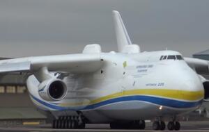 За забором авиабазы собрались люди, которые наблюдали за взлетом самого большого в мире самолета