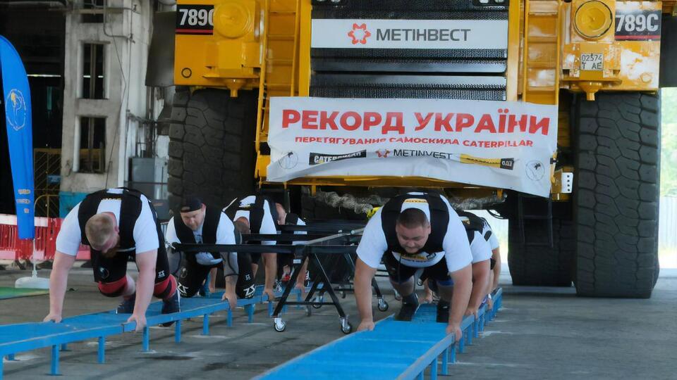 Команда спортсменов сдвинула загруженный породой самосвал на полметра