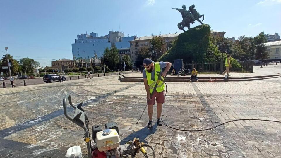 Площу відмивають струменем води під високим тиском