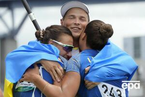 Четверикова и Лузан обнимаются с главным тренером сборной Украины по гребле на байдарках и каноэ Юрием Чебаном после финального заезда