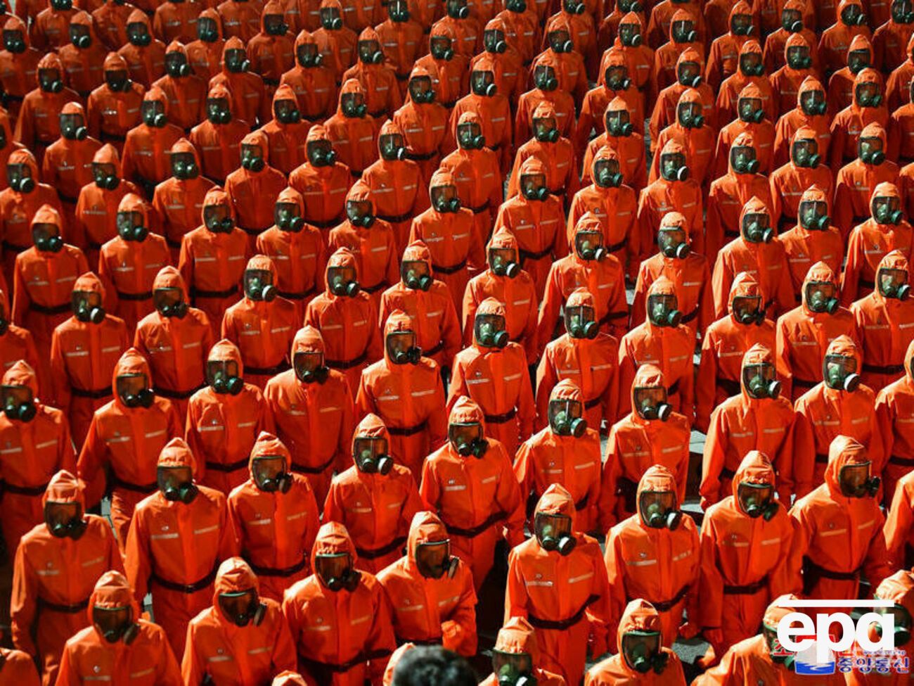 На параде были демонстранты,&nbsp;одетые в оранжевые костюмы химзащиты и противогазы