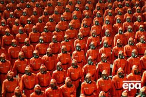 На параде были демонстранты, одетые в оранжевые костюмы химзащиты и противогазы