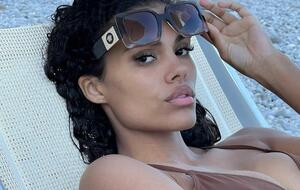 Образ Тины Кунаки дополнили черные высокие чулки-ботильоны с каблуком-рюмкой от Amina Muaddi