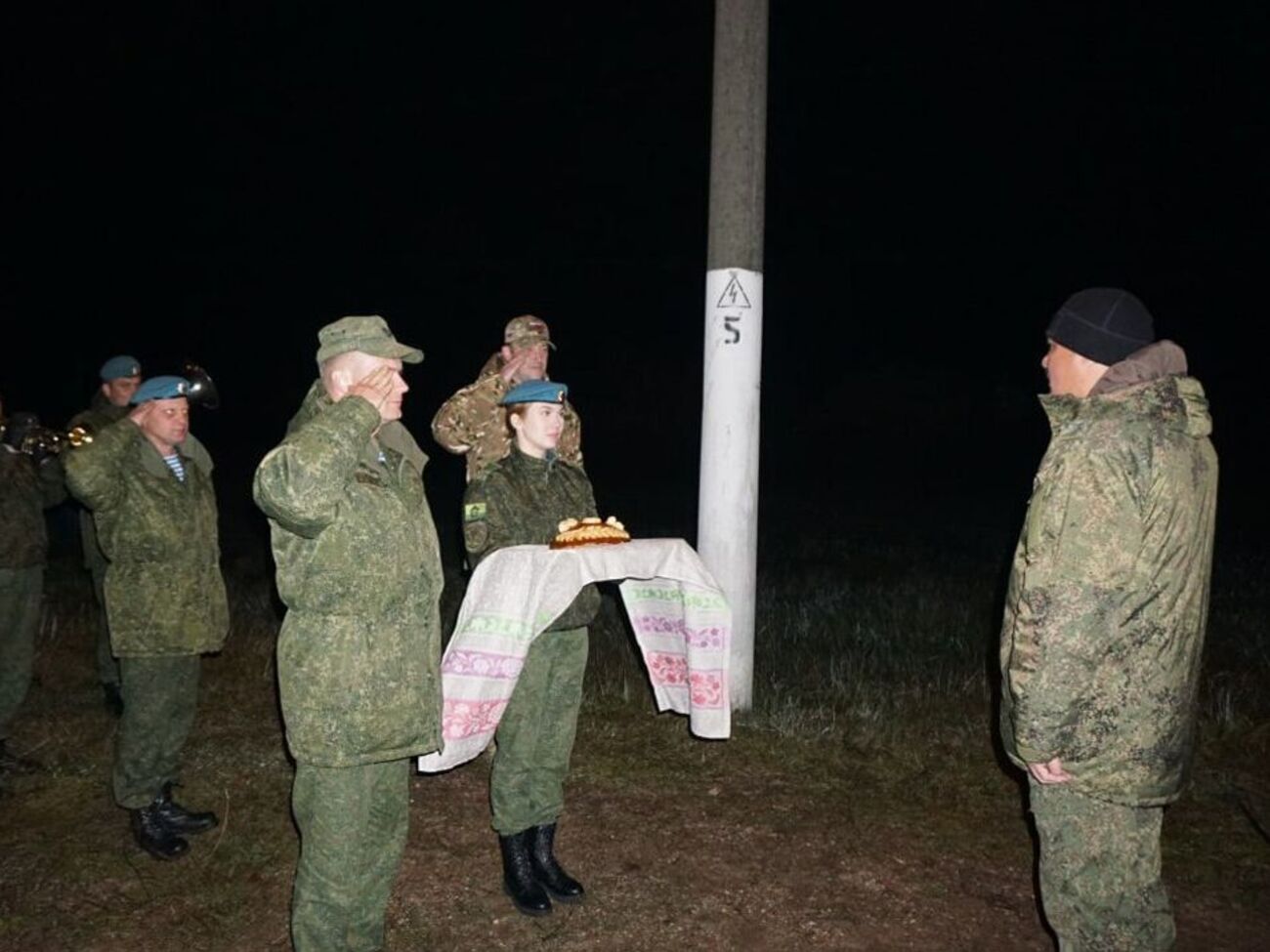 На фото российских военных без оружия и вещей встречают с хлебом-солью и оркестром