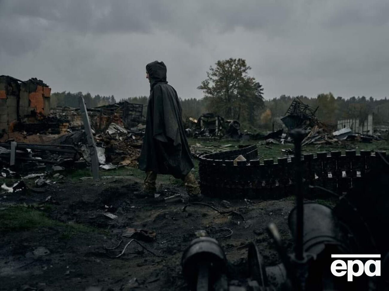 Любовь стоит на фоне техники оккупантов, уничтоженной силами ее подразделения