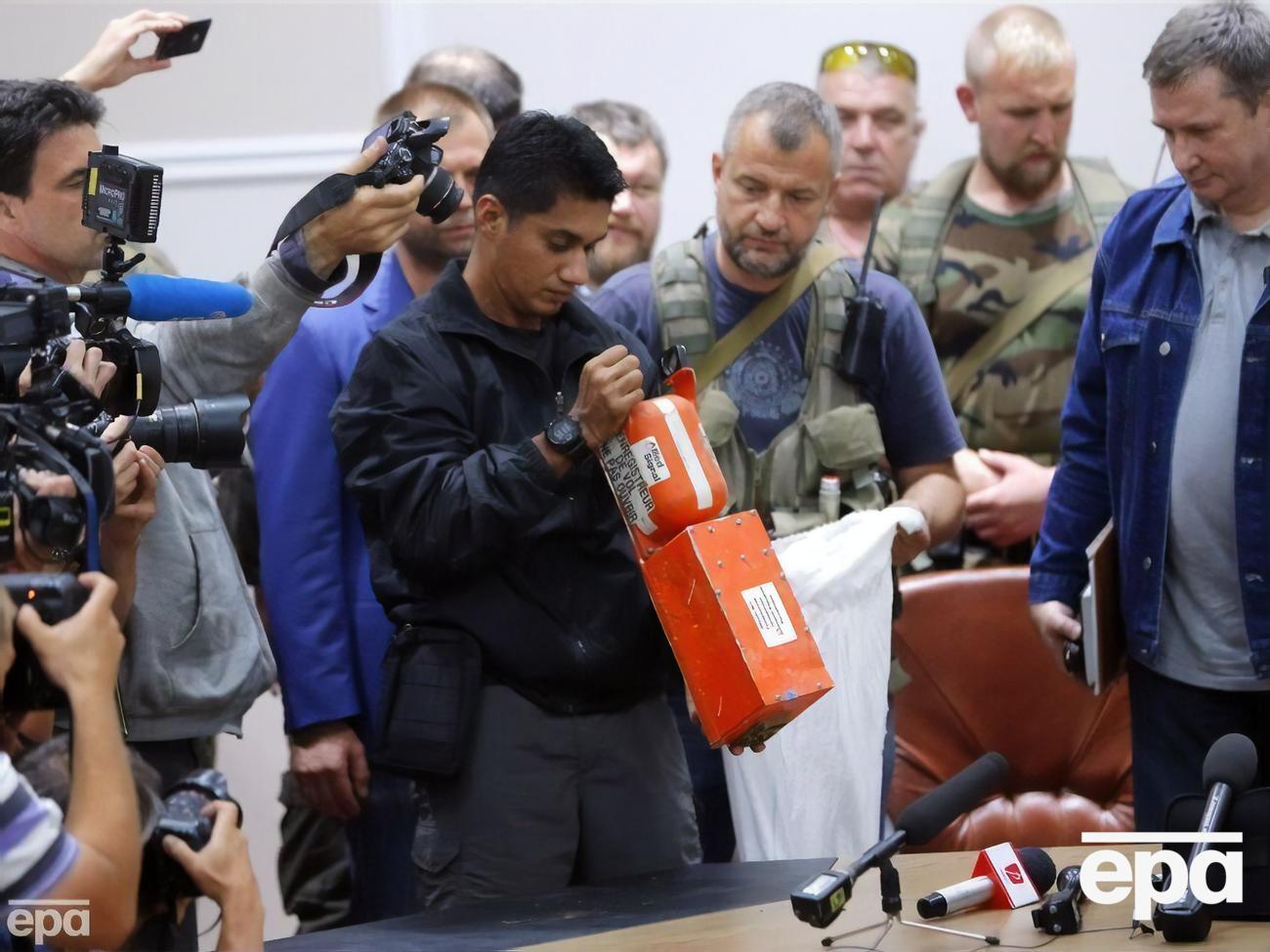 Малайзийский эксперт в присутствии боевиков "ДНР" и журналистов&nbsp;в Донецке осматривает черный ящик сбитого&nbsp;Boeing 777 21 июля 2014 года