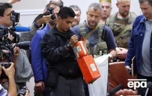 Малайзийский эксперт в присутствии боевиков "ДНР" и журналистов в Донецке осматривает черный ящик сбитого Boeing 777 21 июля 2014 года