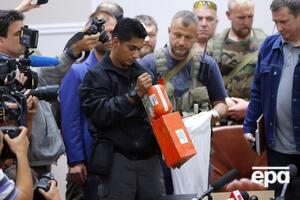 Малайзийский эксперт в присутствии боевиков "ДНР" и журналистов в Донецке осматривает черный ящик сбитого Boeing 777 21 июля 2014 года