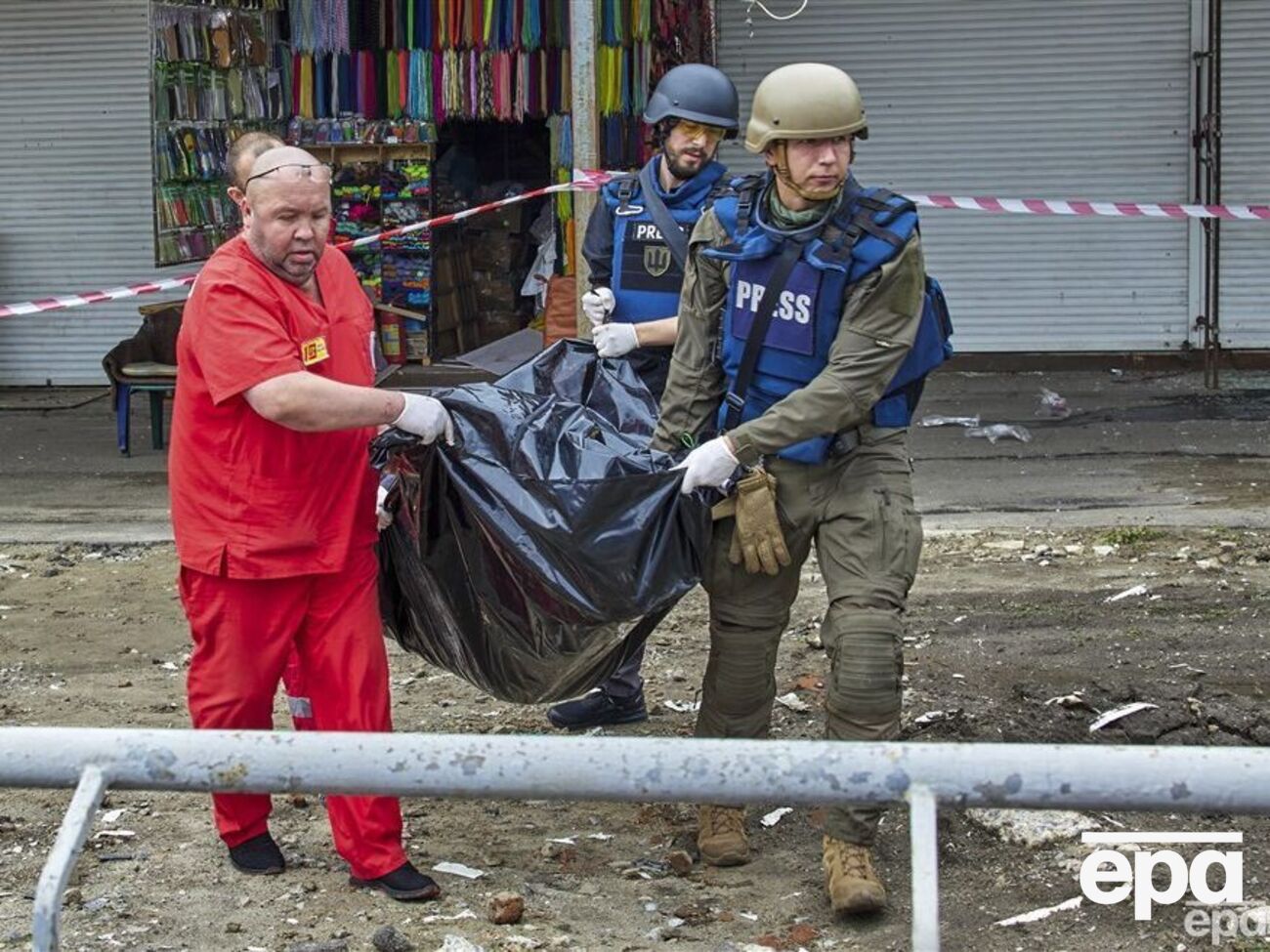 На фото июль 2022 года, журналисты в Харькове помогают медикам нести тело гражданского, погибшего в результате российского обстрела