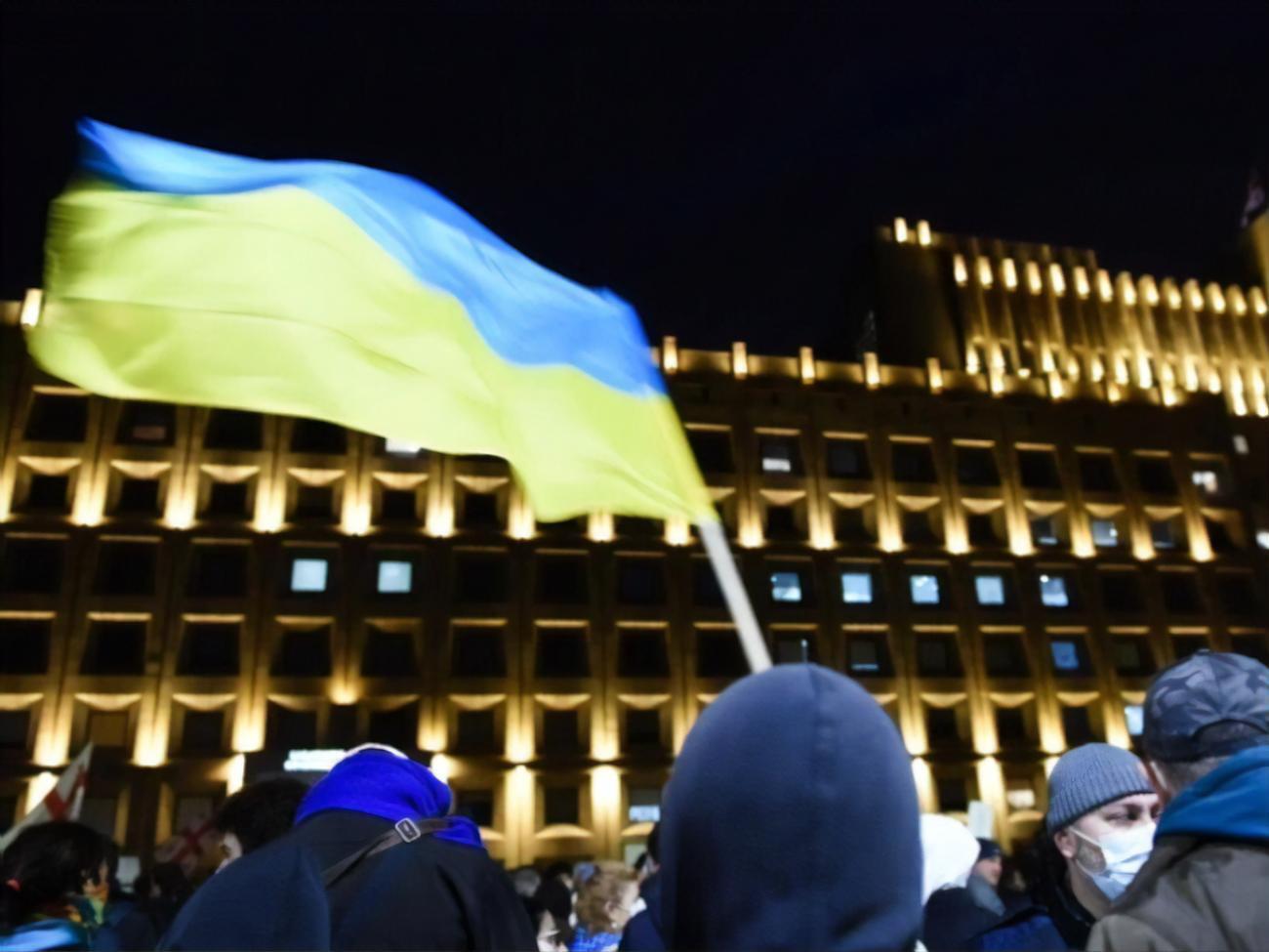 Участники акции держат в руках флаги Грузии и Украины и скандируют "Украина"