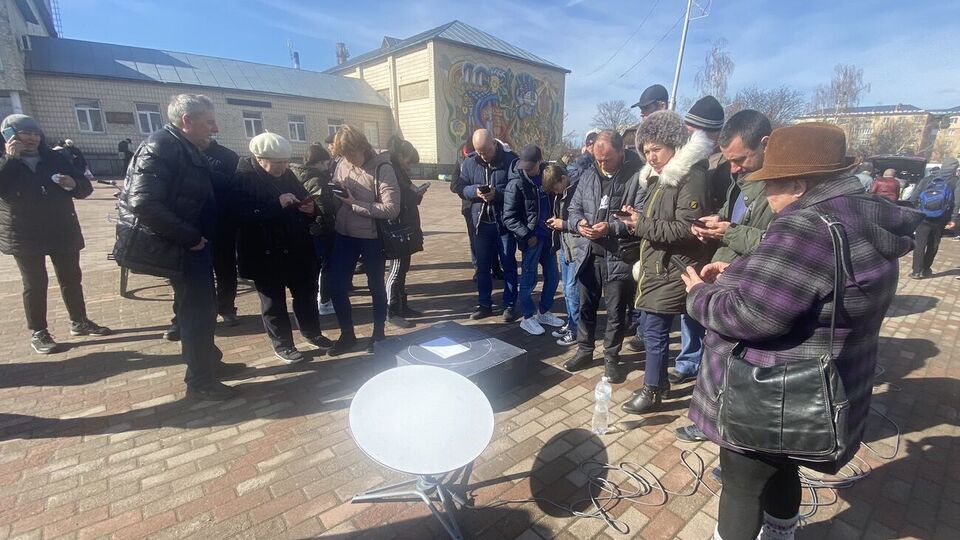 В населенных пунктах, где российские оккупанты повредили линии связи, используют спутниковый интернет. На фото – жители Иванкова Киевской области впервые после освобождения поселка связываются с родными с помощью Starlink