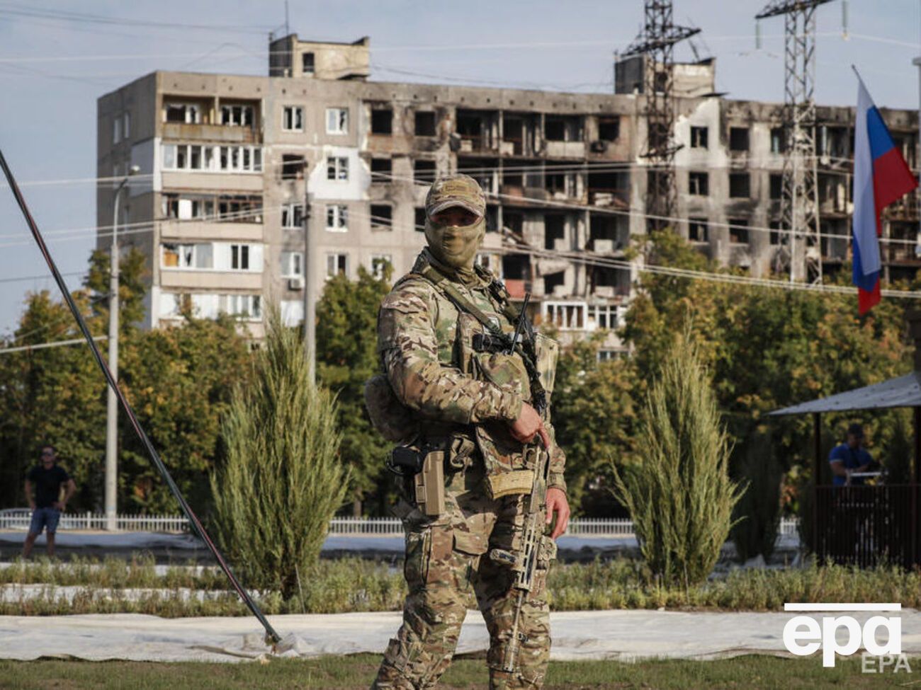 Російський військовий на тлі зруйнованого будинку