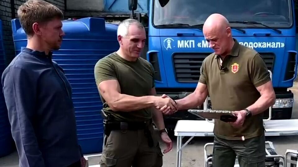 Труханов (справа) вручил Сенкевичу (по центру) почетное отличие