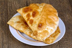 Готові чебуреки перекладайте на паперовий рушник, щоб він усотав зайвий жир