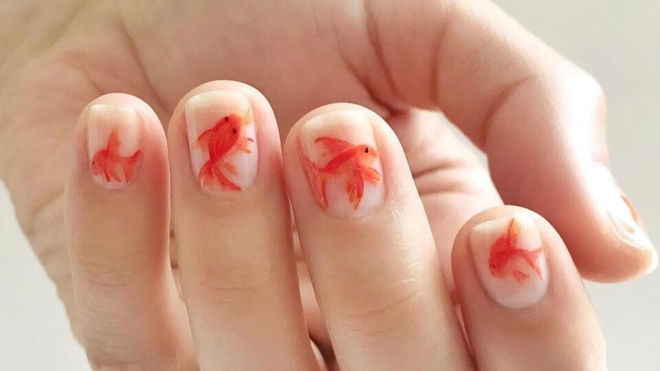 Манікюр із золотими рибками має такий вигляд, ніби для нього використали акварельні фарби