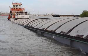 В барже появилась пробоина в правом борту, она стала набирать воду и тонуть