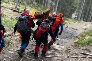 Пострадавшего мужчину на носилках перенесли на базу "Заросляк"