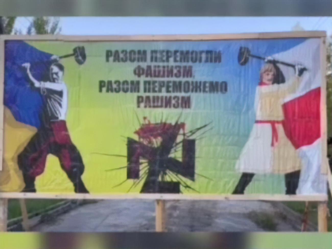 На білборді зображено українця й білоруса, які б'ють по свастиці, котра водночас схожа на дві з'єднані Z