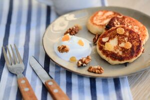 Сырники подаются с орехами и кремом