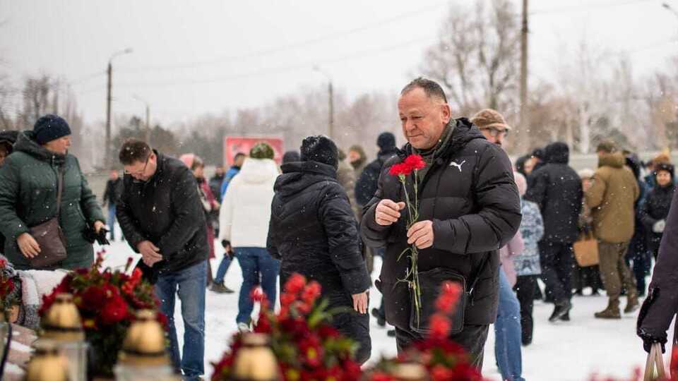 К руинам дома принесли цветы, игрушки, портреты погибших