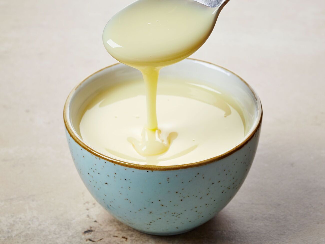 Если перед приготовлением добавить в смесь сухое молоко, сгущенка будет иметь более светлый оттенок