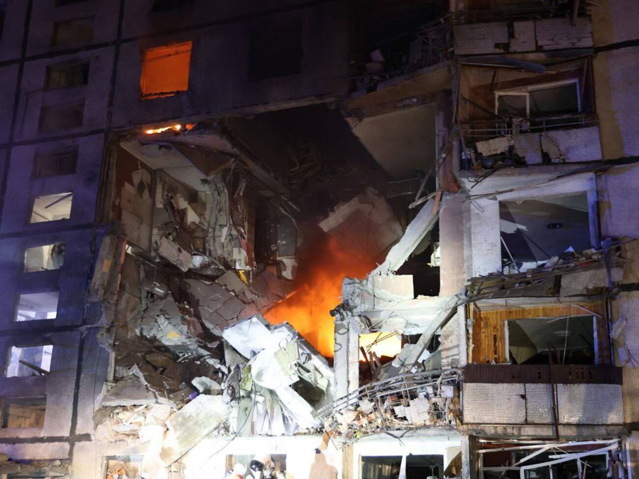 Спасатели ищут людей под завалами и тушат пожар в доме, в котором российская бомба обрушила почти весь подъезд